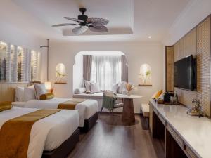 a hotel room with two beds and a television at Sarai Resort & Spa and The Wander in Siem Reap