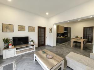 un soggiorno con divano e TV di Bidda Mores Appartamenti- Il Cacciatore a Capoterra