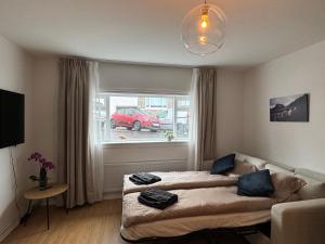 a living room with a couch and a window at Central Pearl Apartment in Reykjavík
