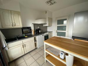 Una cocina con gabinetes blancos y una encimera de madera. en T2 centre ville avec vue imprenable, en Chambéry