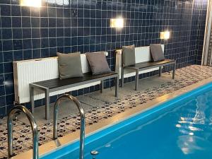 a couple of benches sitting next to a swimming pool at Berghotel HARZ in Hahnenklee-Bockswiese