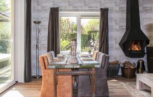 ein Esszimmer mit einem Tisch und einem Kamin in der Unterkunft Vlak aan het bos genieten van de rust & natuur. in Putten