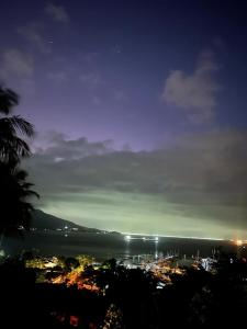 a view of a city at night with the ocean at Casa Yacht Club in Ilhabela