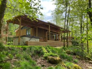 eine Holzhütte im Wald mit Bäumen in der Unterkunft Domaine du Hygge Chalets Lodges & Spa in Anould
