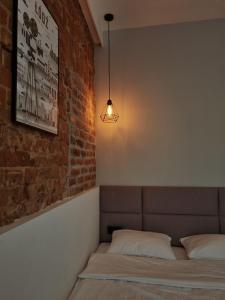 a bedroom with a bed and a brick wall at Kamienica Łódzka in Łódź