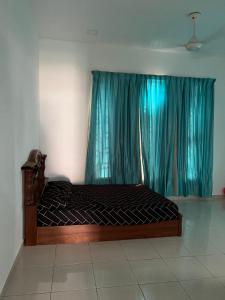uma cama num quarto com uma janela com cortinas azuis em Amir homestay kg pandan em Kuantan