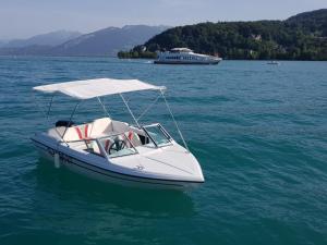 un bateau blanc avec un auvent sur l'eau dans l'établissement Sommeiller à 2 min du Lac, à Annecy
