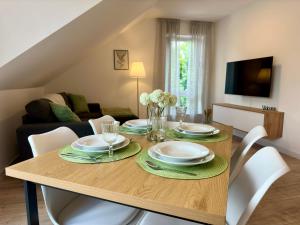 un comedor con una mesa con platos y sillas en Zentrale Wohnung 6 - Kostenloser Parkplatz - HDZ - Bali Therme - GOP, en Bad Oeynhausen