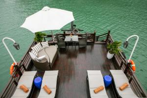 a boat with a table and an umbrella on the water at Bhaya Halong Cruises in Ha Long