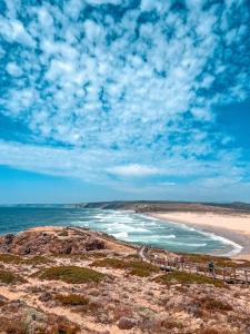 een groep mensen die langs een strand lopen bij Casa Dom Simões in Aljezur