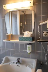 a bathroom with a sink and a mirror at RATSKELLER Hotel & Restaurant in Kröv