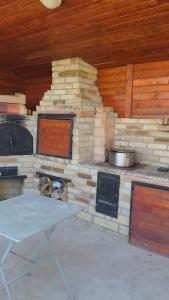 an outdoor kitchen with a stove and a table at Giulia Home in Dezmir