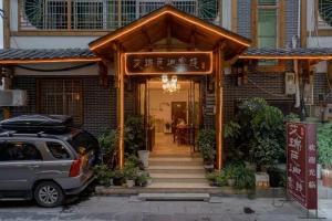 une maison avec une voiture garée devant elle dans l'établissement Zhangjiajie Tianmen Mountain Aribadi Inn, à Zhangjiajie