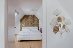 1 dormitorio con cama blanca y pared en Ferienhaus am HerbstHof, en Leutschach