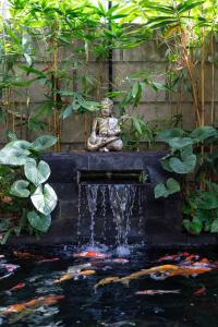 eine Statue auf einem Teich mit Kiwi in der Unterkunft Tahlia's Villa in Sorongjukung