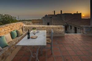 a table and chairs on a rooftop patio with a sunset at Kapetan Matapas 16th Cen. Tower in Areopoli