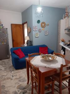 sala de estar con sofá azul y mesa en Casa al centro, en Raffadali