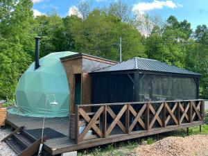 a dome tent on a deck with a fence at NORTH GLAMPER 富良野 in Kami-furano