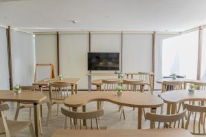 ボラカイにあるMandarin Nest Boracayのテーブルと椅子、薄型テレビが備わる教室です。