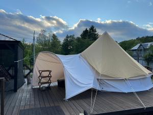 a tent on the deck of a house at NORTH GLAMPER 富良野 in Kami-furano