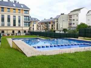 a swimming pool in a yard with buildings at Atalaia Apartment Foz in Foz