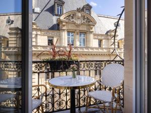 a balcony with a table and chairs and a building at Hotel Mercure La Sorbonne Saint-Germain-des-Prés in Paris