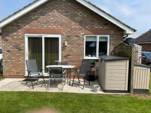 un patio con sillas y una mesa frente a una casa en 2 Bedroom Dog Friendly Cottage near Bridlington, en Bridlington