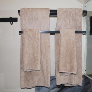 2 asciugamani appesi a un portasciugamani in bagno di The Little Home ad Arusha