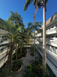 a view of the courtyard of a building with palm trees at LINDO APTO ITAGUA (UBATUBA) in Ubatuba
