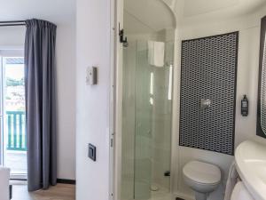 uma casa de banho com um WC e uma cabina de duche em vidro. em ibis Ciboure Saint-Jean-de-Luz em Ciboure