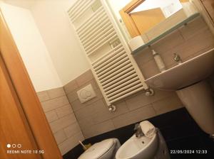 a small bathroom with a toilet and a sink at Hotel Okinawa in Rimini