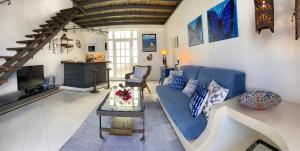 Finca Angelus Amazing Views Sea + Teide في La Matanza de Acentejo: غرفة معيشة مع أريكة زرقاء وطاولة