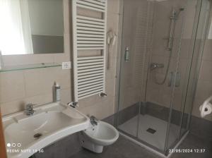 a bathroom with a sink and a shower and a toilet at Hotel Okinawa in Rimini