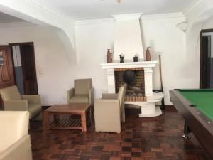 a living room with a fireplace and a pool table at Iarimbato Hotel in Antananarivo