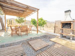 un patio con mesa, sillas y chimenea en Cortijo El Pinar 1, en Níjar