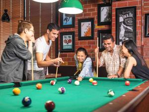 a group of people standing around a pool table at Ibis Styles Dragon Mart Dubai in Dubai
