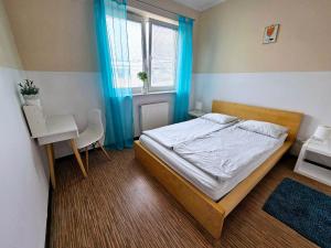 a bedroom with a bed and a desk and a window at Fresh Green Kabaty apartment 4 in Warsaw