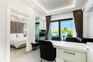 Habitación de hotel con cama, escritorio y sillas en Edem Apartments en Kemer