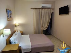 1 dormitorio con 1 cama y ventana con aire acondicionado en Poseidon Hotel Karystos en Karystos