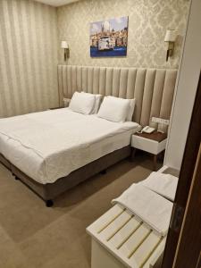 a bedroom with a large bed with white sheets at Mr BEYAZ HOTEL in Istanbul