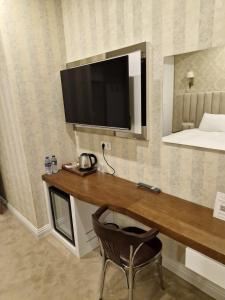 Habitación con escritorio, TV y silla. en Mr BEYAZ HOTEL en Estambul