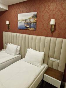 a hotel room with two beds with white sheets at Mr BEYAZ HOTEL in Istanbul