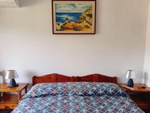 a bedroom with a bed and two tables with lamps at Appartamento Luisa E in Villasimius