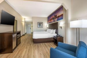 een hotelkamer met een bed en een flatscreen-tv bij Clarion Pointe Louisville East in Louisville