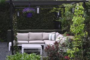 un sofá blanco sentado en medio de un jardín en Quiet and spacious holiday home, en Voorthuizen