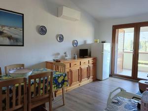 a kitchen with a dining table and a refrigerator at Appartamento Luisa E in Villasimius