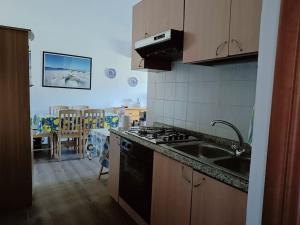 a kitchen with a sink and a stove top oven at Appartamento Luisa E in Villasimius