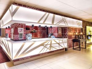 a lobby with a counter with red and white tiles at Mercure Telford Centre Hotel in Telford