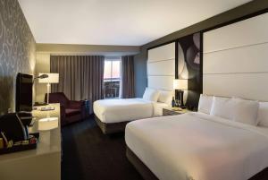 a hotel room with two beds and a television at TRYP by Wyndham Savannah in Savannah