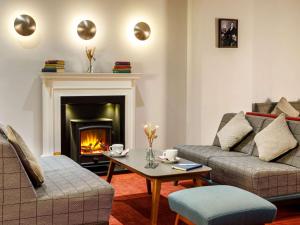 sala de estar con sofá y chimenea en Mercure Telford Centre Hotel en Telford